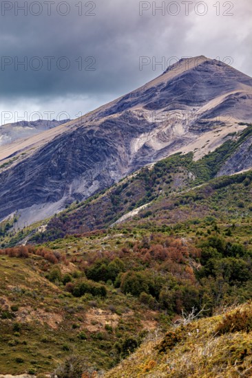 Imposing mountain with steep slopes and dense vegetation under a cloudy sky, the Patagonian landscape near El Chalten in Argentina