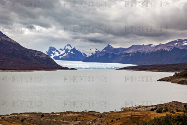 Tranquil landscape with a large lake and glaciers, surrounded by cloudy mountains, The Perito Moreno glacier in Argentina