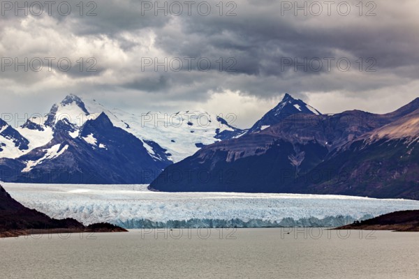 Vast landscape with an impressive glacier and snow-covered mountains under a cloudy sky, The Perito Moreno glacier in Argentina