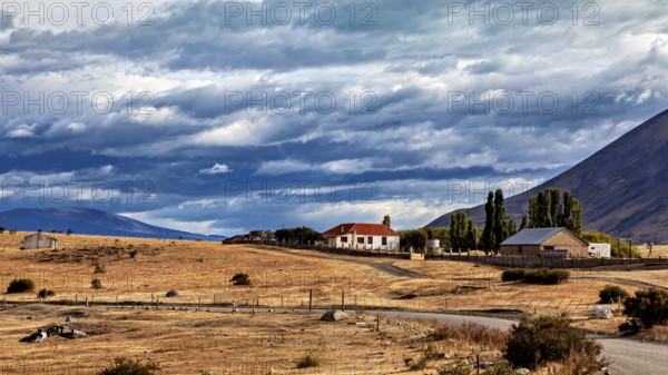 Lonely house in a rural setting with fields and mountains under a dramatic sky, The Patagonian landscape near El Chalten in Argentina