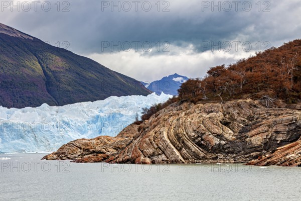 Frozen glacier water meanders between rocks and colourful forests, The Perito Moreno glacier in Argentina