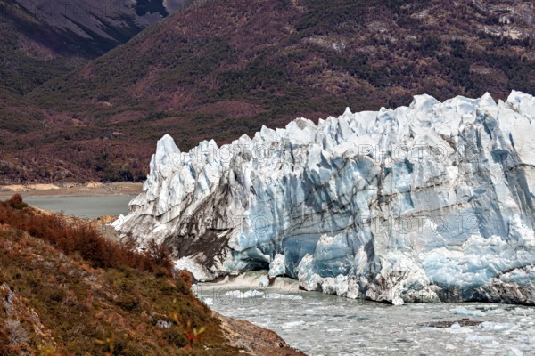 Spectacular ice formations of the glacier with mountain hills in the background, The Perito Moreno glacier in Argentina