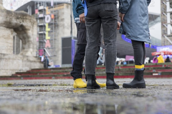 Festival visitors with rubber boots in front of the Olympic Stadium at the Lollapalooza Festival in the Olympic Stadium and on the Maifeld, Berlin, 12.07.2025