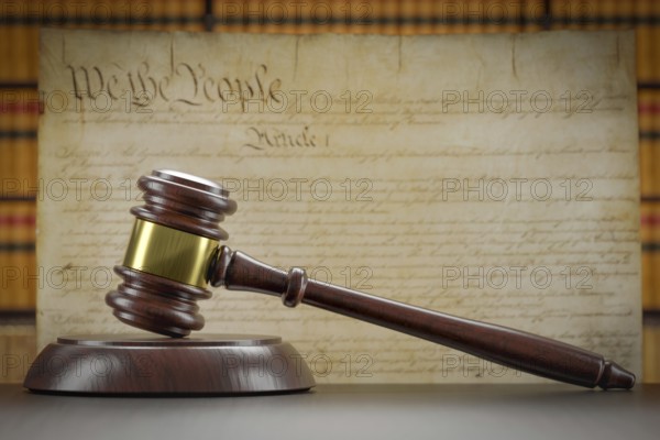 United states constitution on wall with gavel resting on table in front