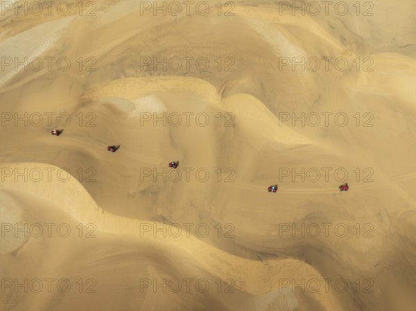 Quad bikes in the dunes of the Namib Desert in the vicinity of the coastal town of Swakopmund. Aerial view. Drone shot. Namibia