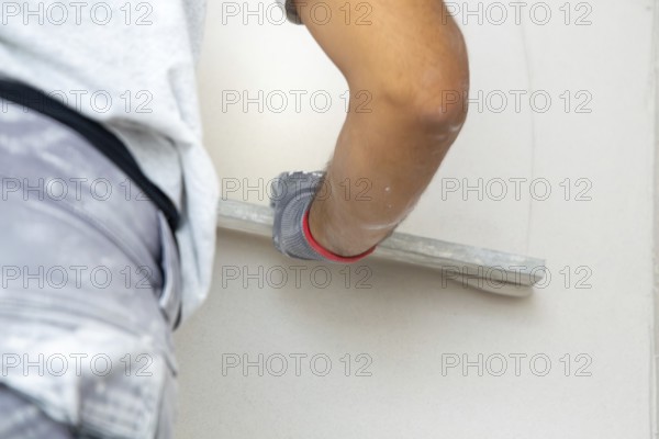 Plasterer smoothing and levelling interior walls