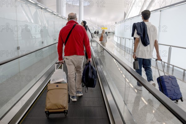 Airport moving walkway Passengers with hand luggage, Abu Dhabi, United Arab Emirates
