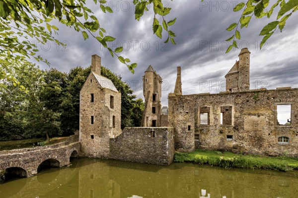 Medieval ruins under a dramatic sky with nature in the foreground, Gratot Castle in Normandy, France