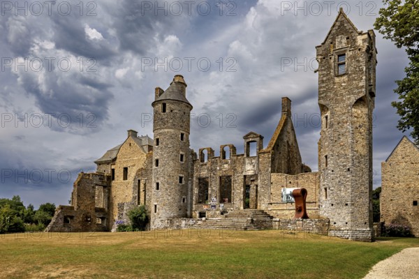 Historic castle ruins with towers under dramatic clouds, Gratot Castle in Normandy, France