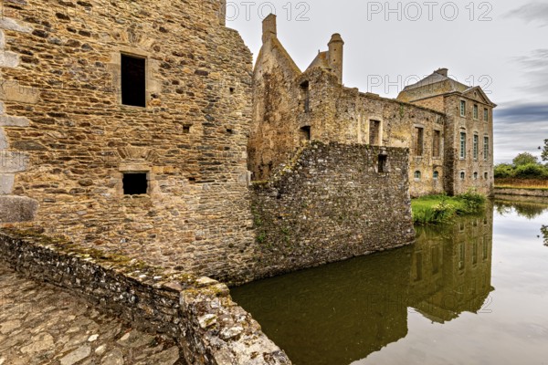 Historic castle with moat and reflection in a tranquil atmosphere, Gratot Castle in Normandy, France