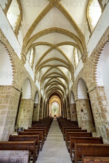 Interior view of a Gothic church with impressive arches and wooden rows of seats, The Abbey de La Lucerne in Normandy, France