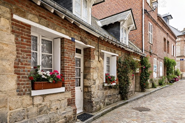 Picturesque old town street with half-timbered houses and blooming flowers in the window boxes, The historic mill village of Veules Les Roses in Normandy, France