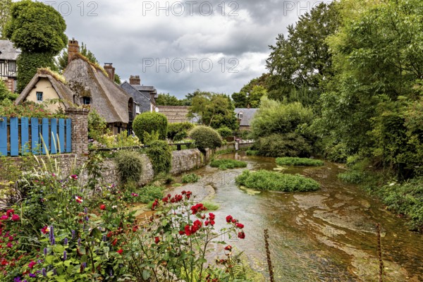 Picturesque landscape with a river and flowering gardens in a village, the historic mill village of Veules Les Roses in Normandy, France