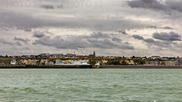 Coastal town with cliffs and a church, under a cloudy sky, The coast of Dieppe in Normandy, France