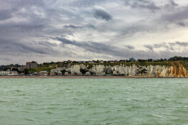 Rocky coast with houses above, under a cloudy sky, The coast of Dieppe in Normandy, France