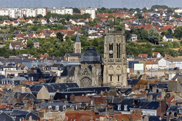 Town view with striking church tower surrounded by old tiled roof houses and green surroundings, The town of Dieppe in Normandy, France