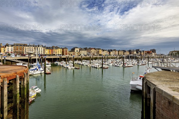 View of a harbour with many boats and historic buildings under a dramatic sky, The harbour of Dieppe in Normandy, France
