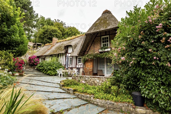 Charming thatched house in a lush garden with traditional architectural elements, the historic mill village of Veules Les Roses in Normandy, France
