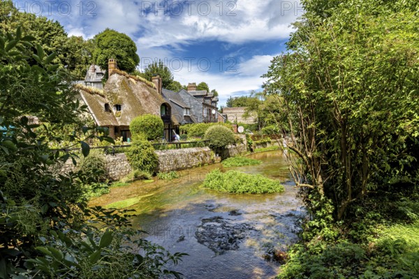 Half-timbered house in the middle of an idyllic landscape with a flowing stream and lush greenery, the historic mill village of Veules Les Roses in Normandy, France
