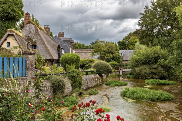 Romantic river landscape with cottages and blooming flowers under a cloudy sky, the historic mill village of Veules Les Roses in Normandy, France