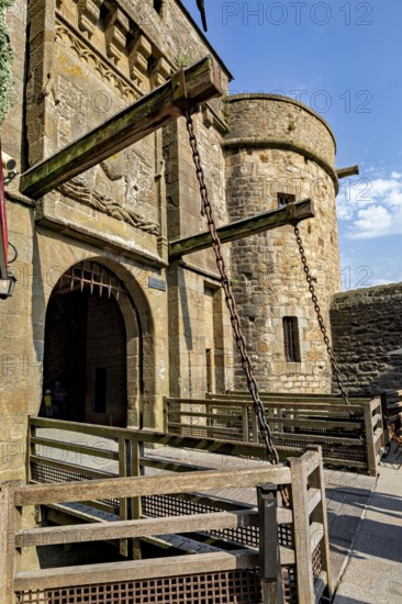 A massive medieval Tor tor with chains and stone walls under a clear sky, Mont Saint Michel in Normandy, France