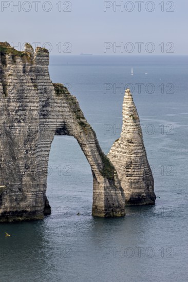 Iconic rock formation with natural arch over the blue sea, The cliffs and alabaster coast of Etretat in Normandy France