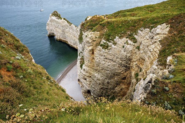 Deep coastal gorge with shallow beach and steep cliffs, The cliffs and alabaster coast of Etretat in Normandy France