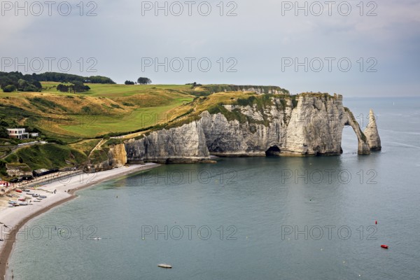 Famous cliff formation with grassy landscape and calm sea, The cliffs and alabaster coast of Etretat in Normandy France