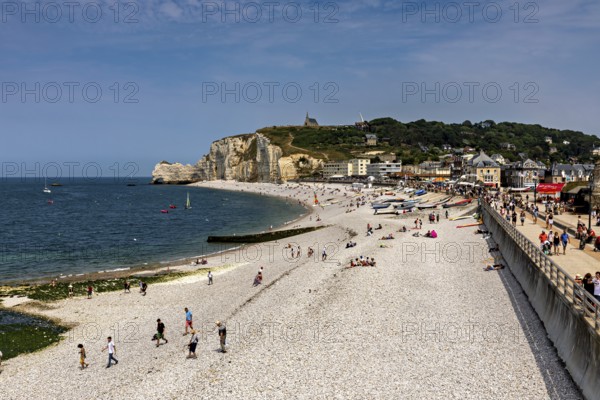 Coastal strip with beach and promenade, numerous walkers by the sea, Etretat in Normandy, France