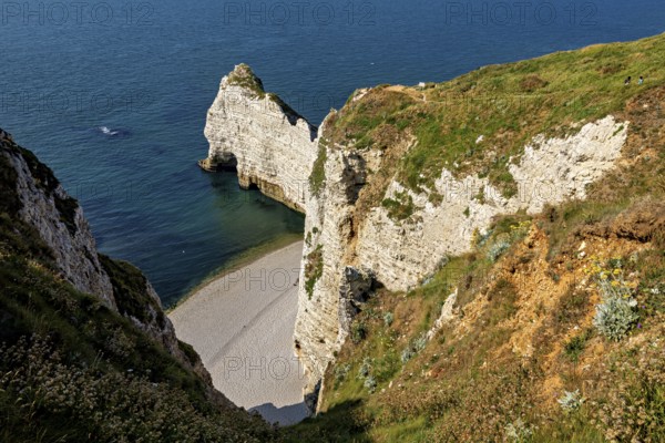 Steep rocks and cliffs with a small hidden beach by the turquoise blue sea, The cliffs and alabaster coast of Etretat in Normandy France