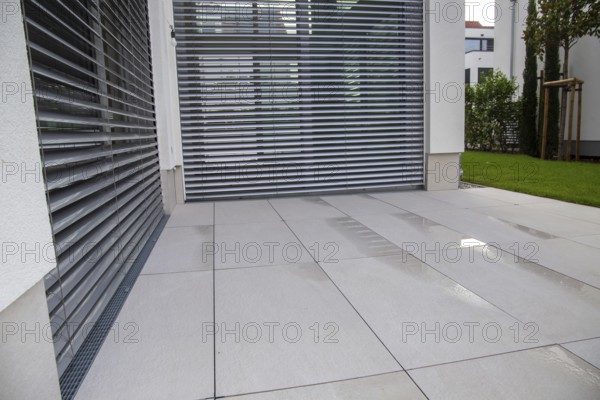 Modern terrace with large, light-coloured terrace tiles on a new detached house