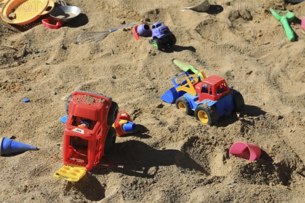 Playground, sandpit with plastic toys, vehicles, shovel