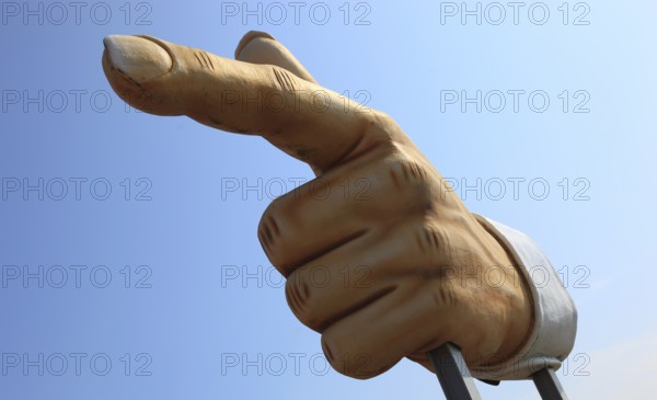 Plastic sculpture of a human hand with an outstretched index finger to indicate a direction