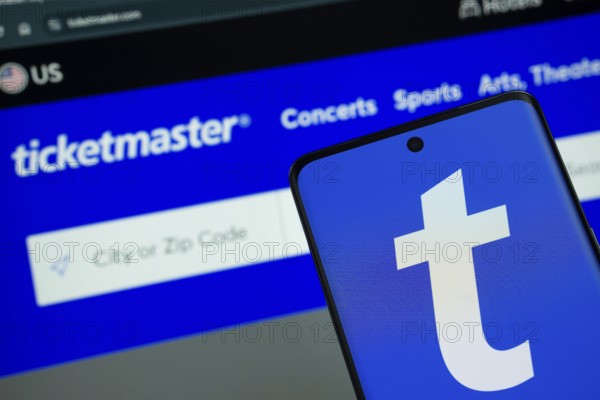 Dhaka, Bangladesh - 18 March 2025: The logo of the Ticketmaster is displayed on a smartphone screen, and the website Ticketmaster is visible on a computer screen in the background