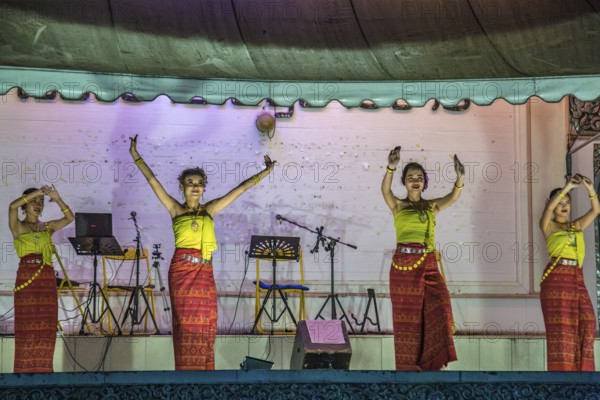 Traditional Thai dancers perform on a lighted stage at the night market in downtown Chiang Rai, Thailand