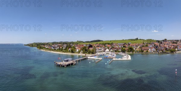 Luftbild, Panorama von der Bodenseegemeinde Hagnau, Winzerdorf und beliebter Ferienort am Bodensee, dahinter Rebhänge, auf denen hauptsächlich die Weinsorten Müller Thurgau und Blauer Burgunder angebaut werden. Am Seeufer der am 23.Mai 2025 eingeweihte, neue Westhafen, Yachthafen mit der Schiffanlegestelle, Bodenseekreis, Baden-Württemberg, Deutschland