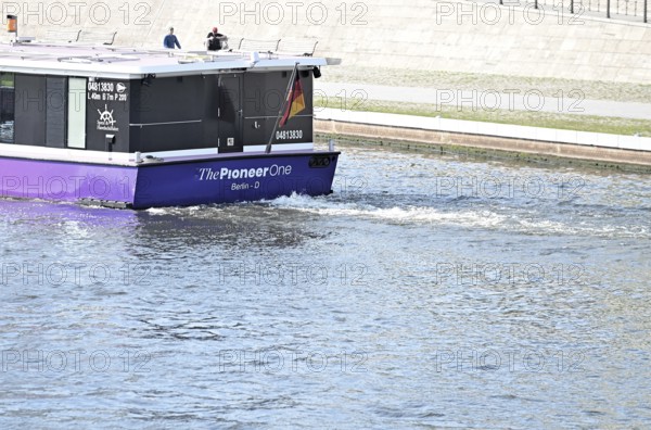 The media ship The Pionieer One sails on the Spree near the Kapelleufer
