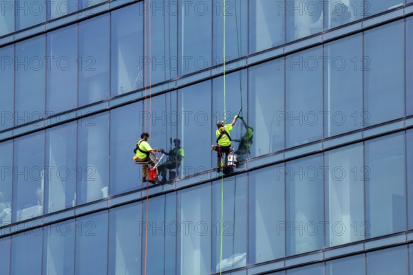 Detroit, Michigan - Window washers at the 25-story Residences Water Square luxury apartment building
