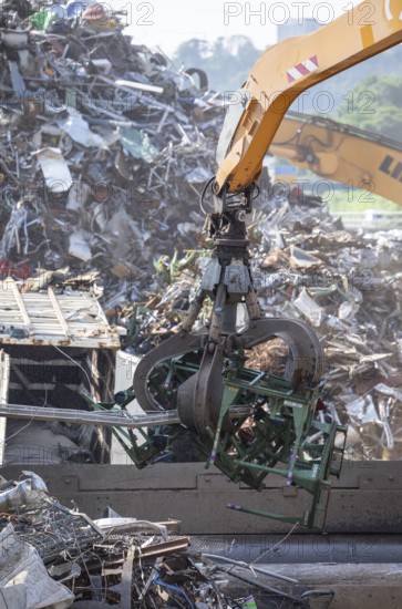 Hydraulic crane lifts scrap metal at the scrap yard