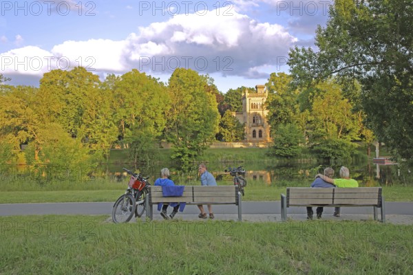 Christian Academy on the Saale and cyclist resting on a bench, leisure, relax, break, rest, enjoy, idyll, riverbank, Saale valley, Saale cycle path, cycle path, reflection, Christian Academy, Halle an der Saale, Saxony-Anhalt, Germany