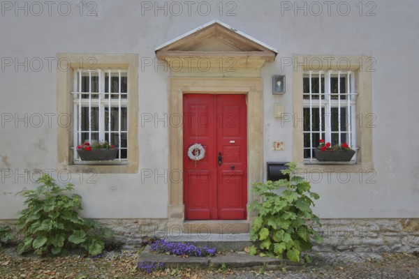 Red front door with floral decoration of the cathedral curia, idyll, two, window, plant growth, Merseburg, Saxony-Anhalt, Germany