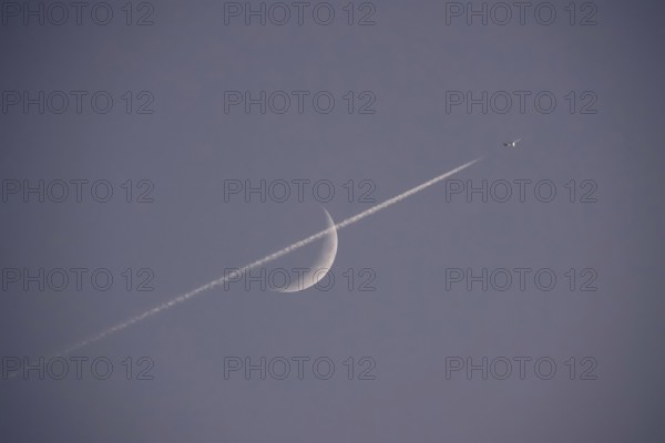 Evening sky with crescent moon and aeroplane, Germany