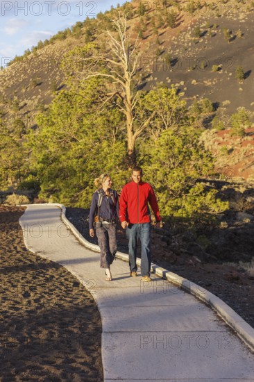 Couple walking on pathway, Sunset Crater Volcano National Monument, Flagstaff, Arizona, USA