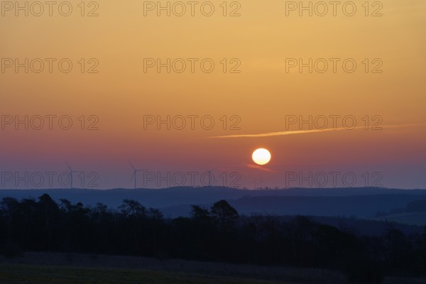Landscape with sunrise over silhouettes of wind turbines on the horizon, Sodenberg, Hammelburg, Rhön, Bavaria, Germany