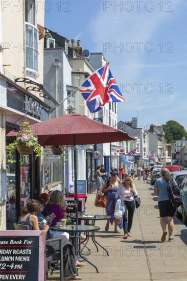 Union Jack flags on shops in street of historic buildings, The Strand, Dawlish, south Devon, England, UK