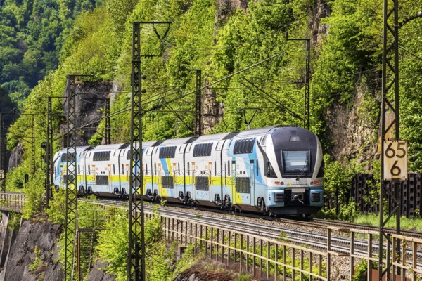Train of the Austrian Westbahn en route on the winding railway line of the Geislinger Steige. Landscape on the railway's Filstalline line in spring. Amstetten, Baden-Württemberg, Germany