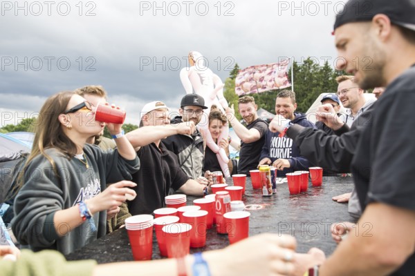 Festival visitors play a drinking game on a campsite at the Rock am Ring Festival on Saturday, Nürburgring race track race track, 07.06.2025