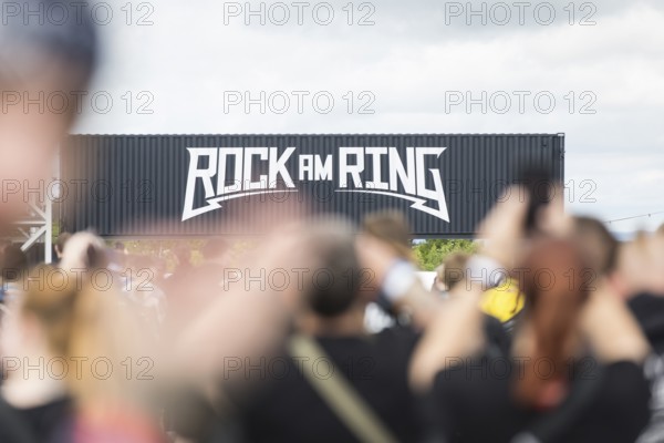 Festival visitors in front of a container with Rock am Ring logo at the Rock am Ring Festival on Friday, Nürburgring race track race track, 06.06.2025