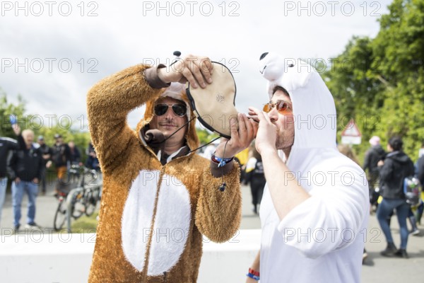 Two festival visitors in animal costumes drink from a horn at the Rock am Ring festival on Friday, Nürburgring race track race track, 06/06/2025