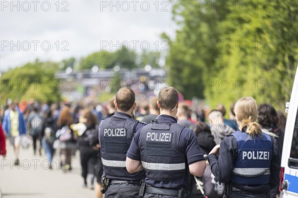 Police officers watch festival visitors on their way to the main entrance at the Rock am Ring Festival on Friday, Nürburgring race track race track, 06/06/2025
